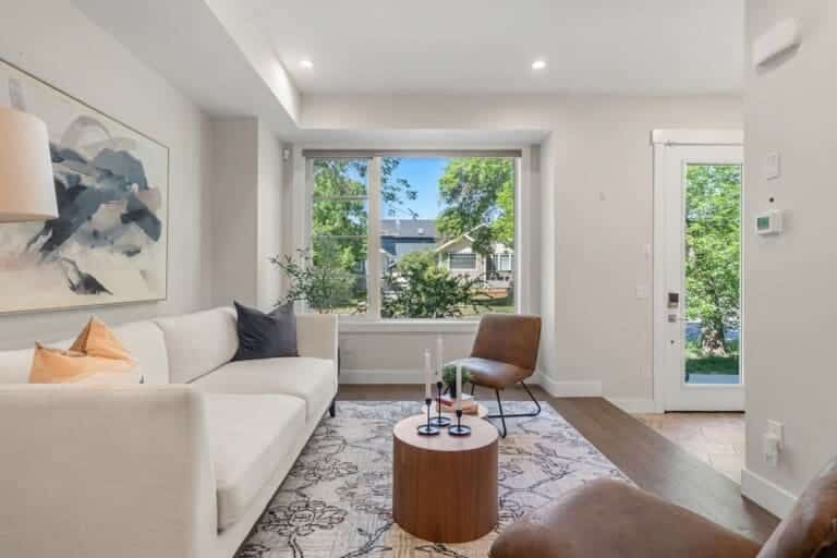 Bright living room with white sofa and garden window in a 4-bedroom Calgary home