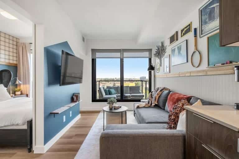 Western-themed living room with sectional sofa and view into the bedroom in a Calgary condo